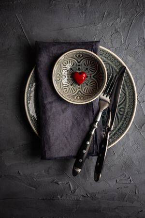 Dark table setting with red heart decoration