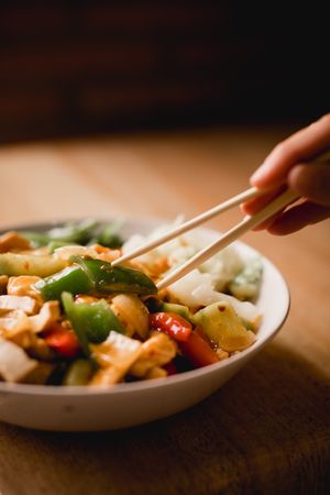 Female eating bowl of cooked appetizing diet dish