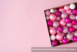 Box of pink festival baubles on pink background bDoY84
