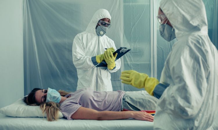 Doctors with bacteriological protection suits examining a patient