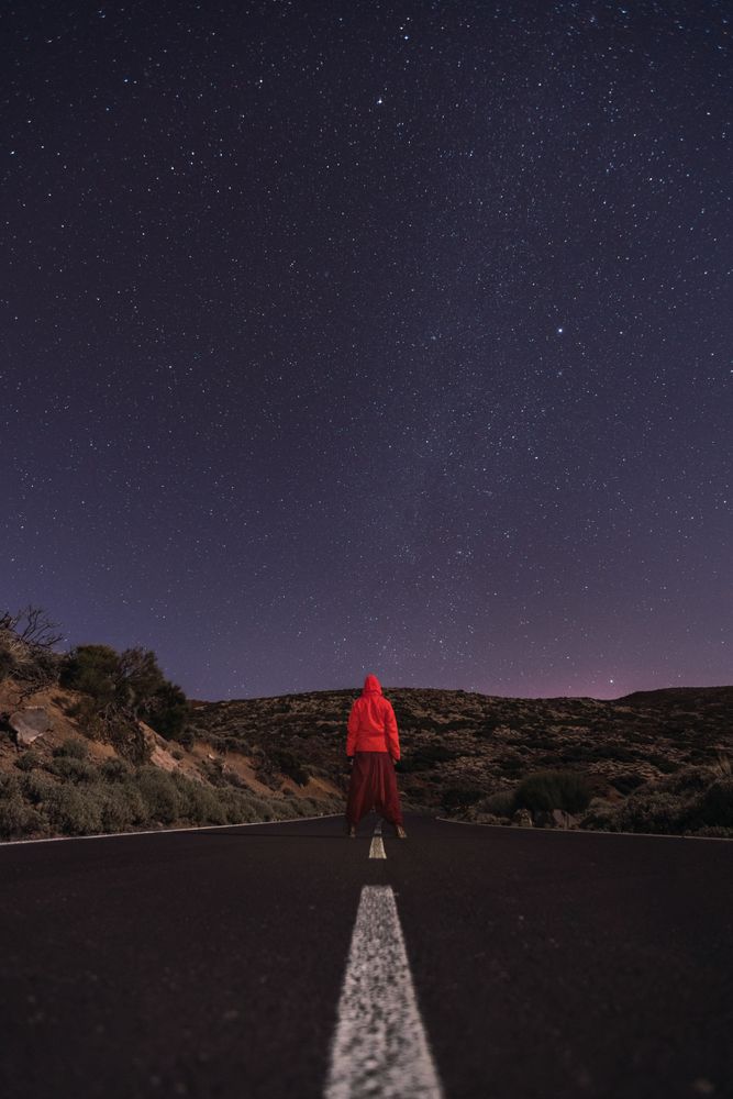Traveler standing on empty road at night