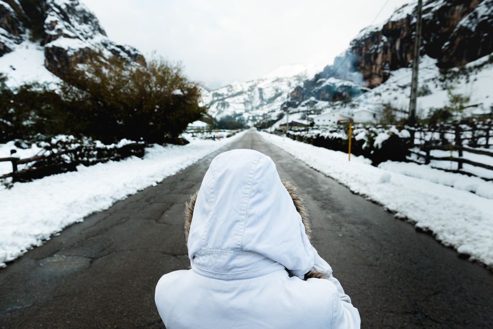 Anonymous person standing on road in countryside