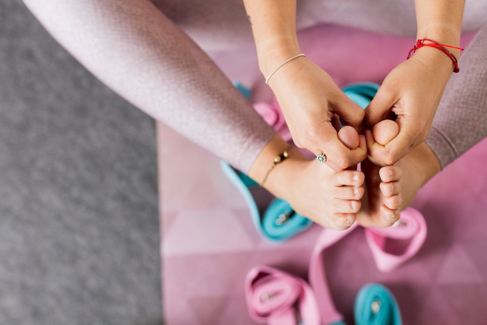 Faceless woman practicing yoga on pink mat