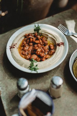 beans hummus in plate close to vegetables plate
