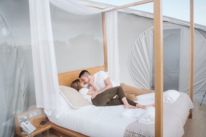 Passionate couple on bed in bubble hotel