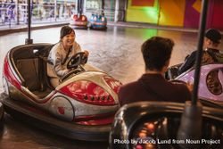 Friends having fun on bumper car ride in amusement park 4dP9L4