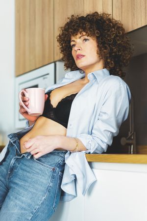 Woman lounging in her kitchen with coffee