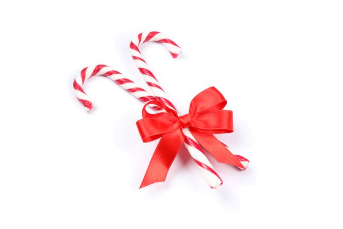 Sweet candy canes with bow isolated on blank background