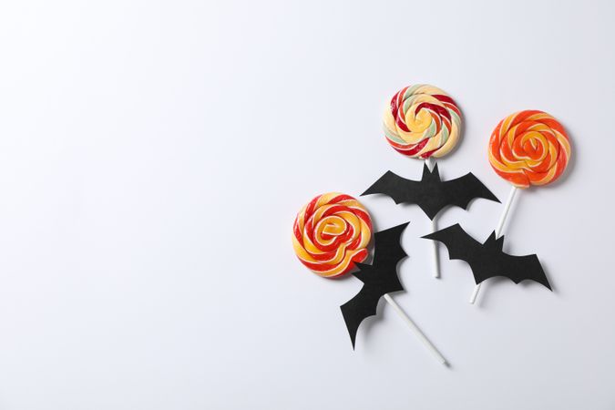 Candy and decorative bats on plain background, copy space