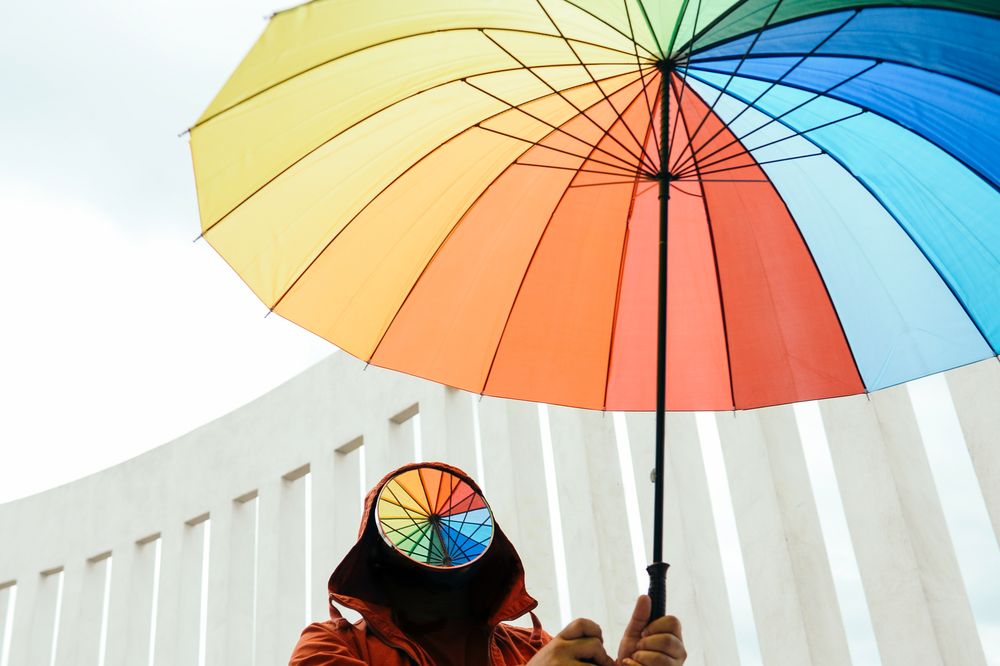 Faceless person holding a large umbrella on overcast day