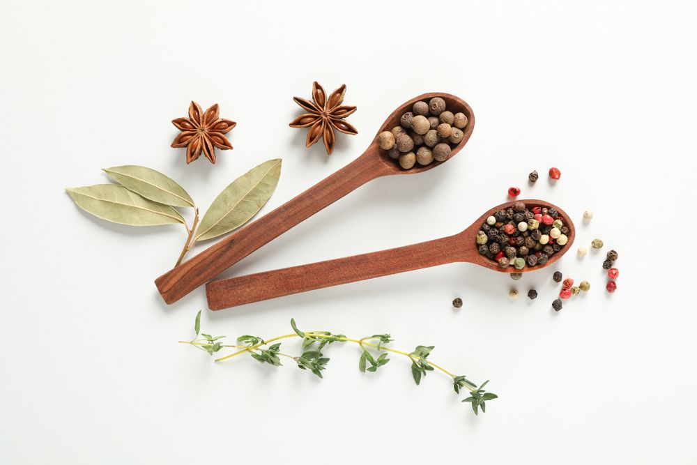 Top view of two wooden spoons full of peppercorn