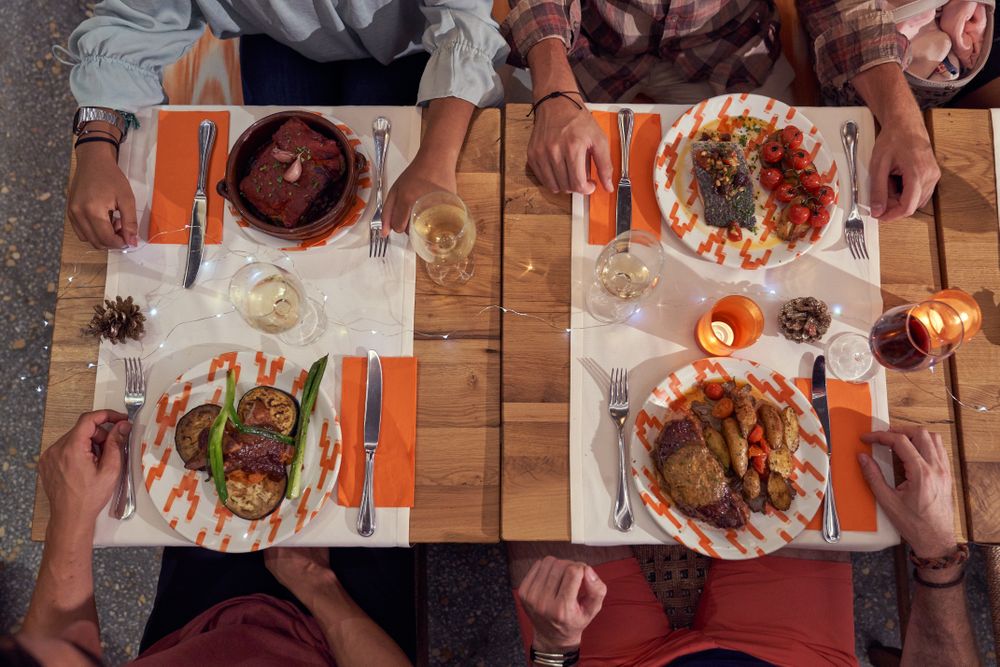 Unrecognizable friends having dinner in restaurant