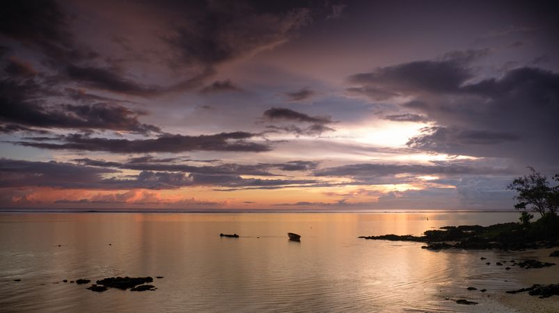Boat and rocks near the shore at dawn
