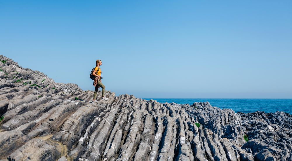 Woman enjoying view on an coastal hike with a camera