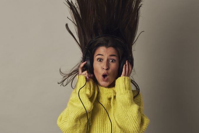 Shocked young woman listening to music in studio
