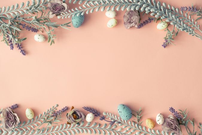 Creative layout made with spring flowers leaves and Easter eggs on pastel pink background