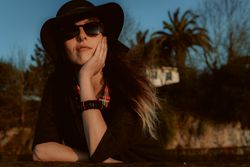 Dreaming stylish woman in sunglasses and hat
