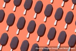 Chocolate popsicle lined up diagonally in diagonal order on an orange background bD6Qp5