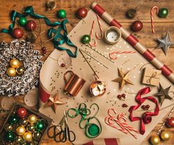 Festive scene with candy canes, star tree ornaments, ribbon, wrapping paper, wreath, copper mugs