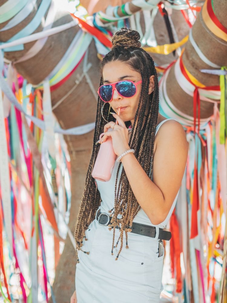 Trendy young woman enjoying beverage during party