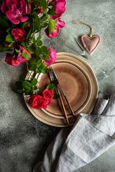 Top view of elegant table setting with roses, champagne flute & heart ornament