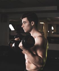 Powerful man exercising with dumbbells