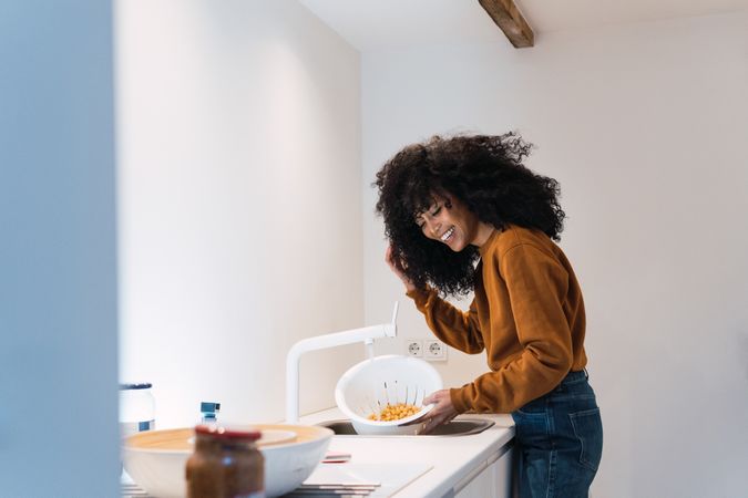 Woman washing chickpeas in sink