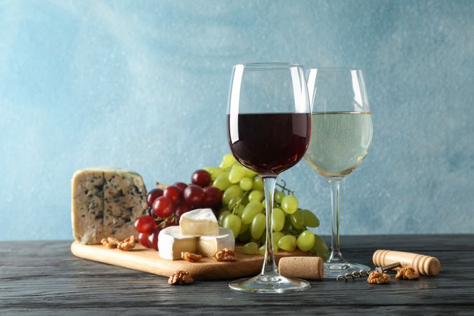 Grape, cheese, corkscrew, glasses with wine, on wooden background, copy space