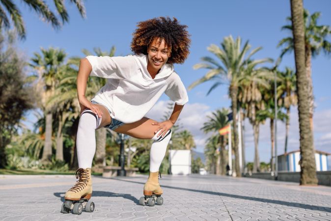 Happy woman on roller skates leaning down