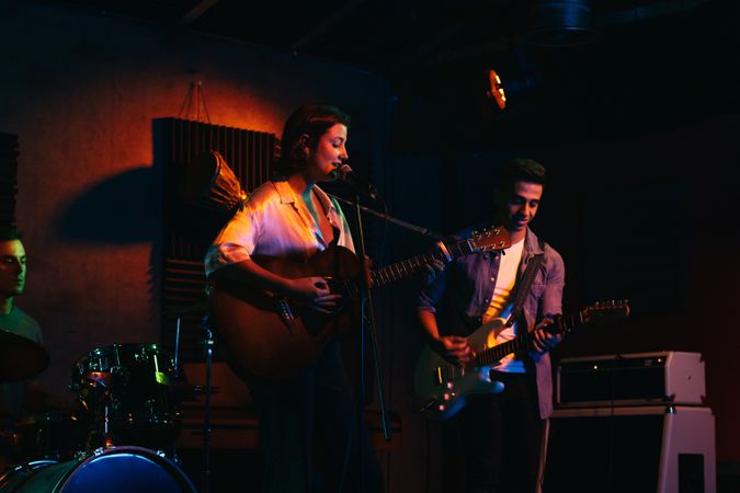 Musicians In Stage With Colorful Lights Performing In A Live Concert