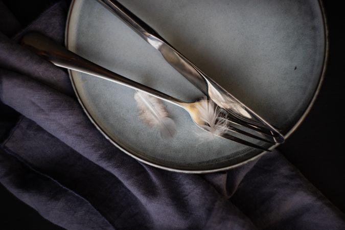 Top view of silverware with feather for Easter decor