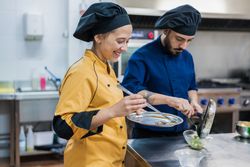 Professional chefs preparing dish in restaurant kitchen