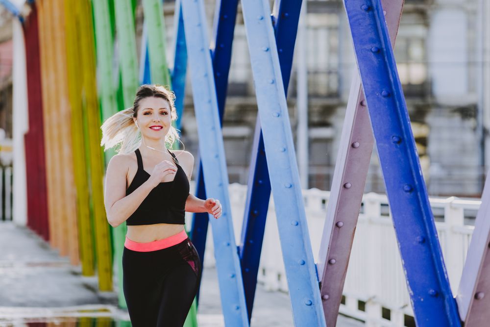 Woman with earphones running on street