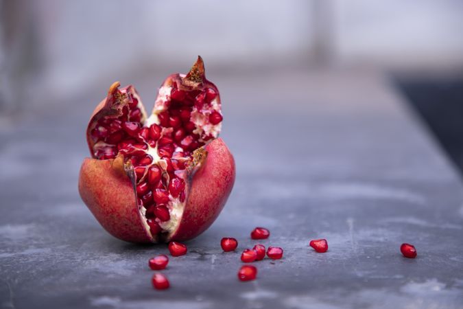 Open pomegranate fruit with seeds on a dark background