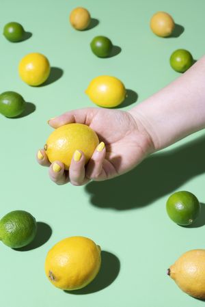 Citrus fruits and hand holding a lemon