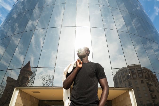 Stylish Black businessman against modern building in city