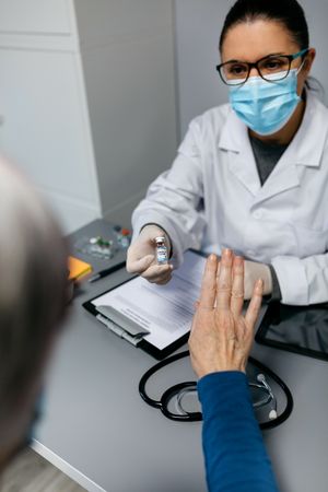 Patient refusing the coronavirus vaccine offered by doctor