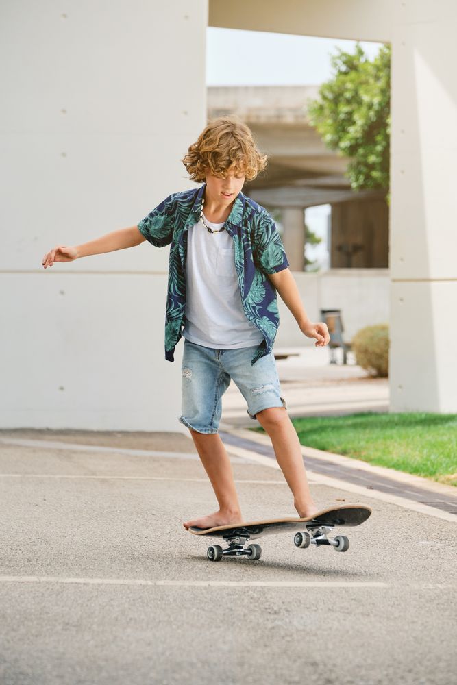 Boy balancing on skateboard on asphalt road