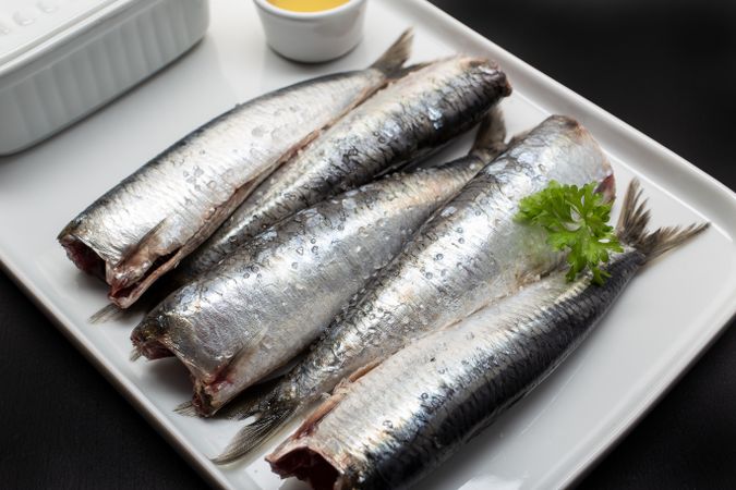 Raw fish without heads on light plate