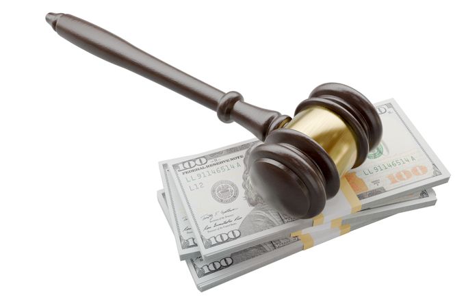 Gavel Resting on Stacks of Thousands of Dollars Isolated