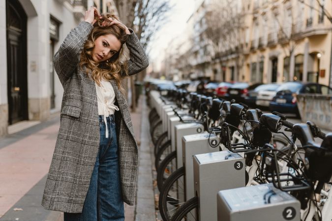 Woman choosing rental bicycle on parking lot