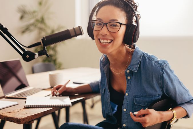 Cheerful female podcast host working from home