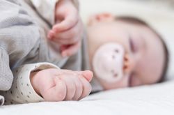 Cute baby girl sleeping over white bedcover