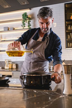 Man pouring oil into pot