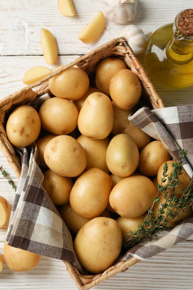 Vertical composition of wicker box of potatoes wrapped in kitchen towel