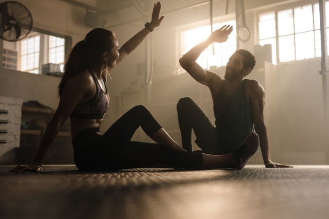 Fit couple high five after workout in health club