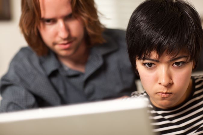 Young Man and Diligent Woman Using Laptop Together