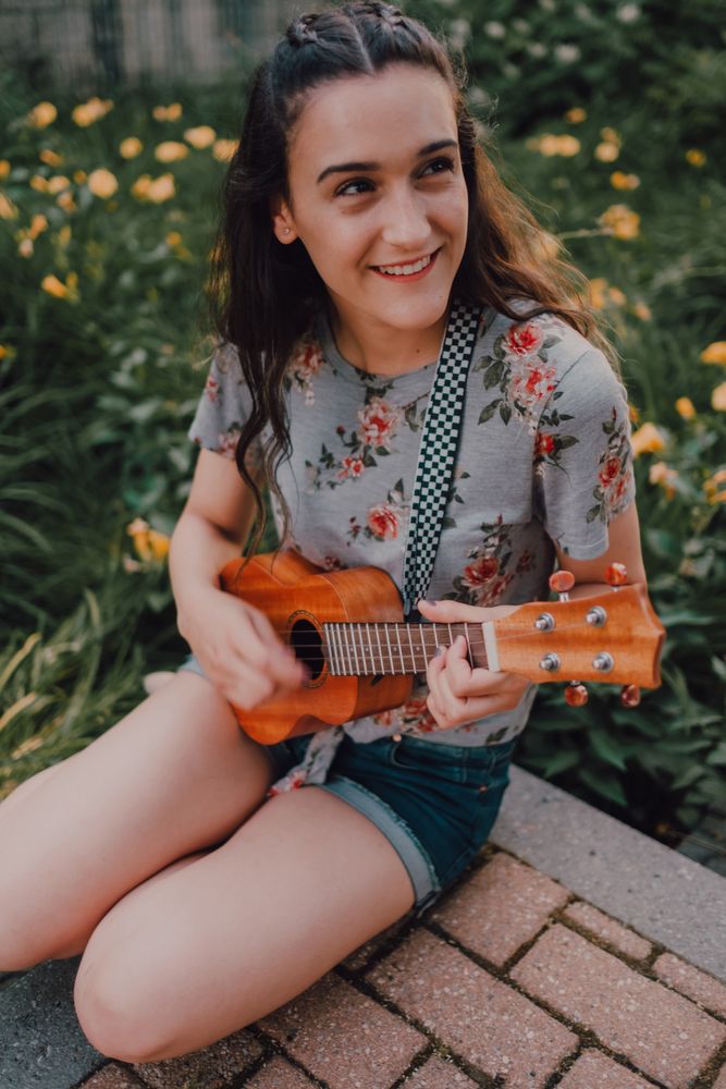 Happy modern woman playing ukulele