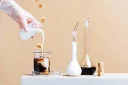 Laboratory for making coffee drinks with coffee and milk in beakers and sugar cubes