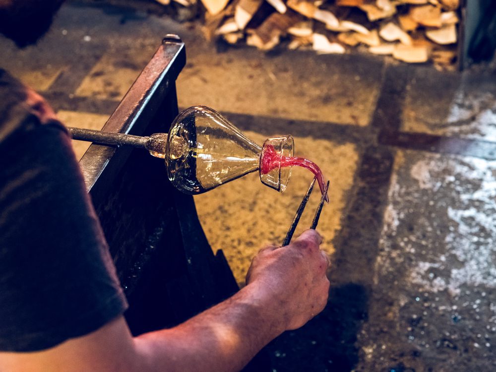 Unrecognizable glassblower making glass vase